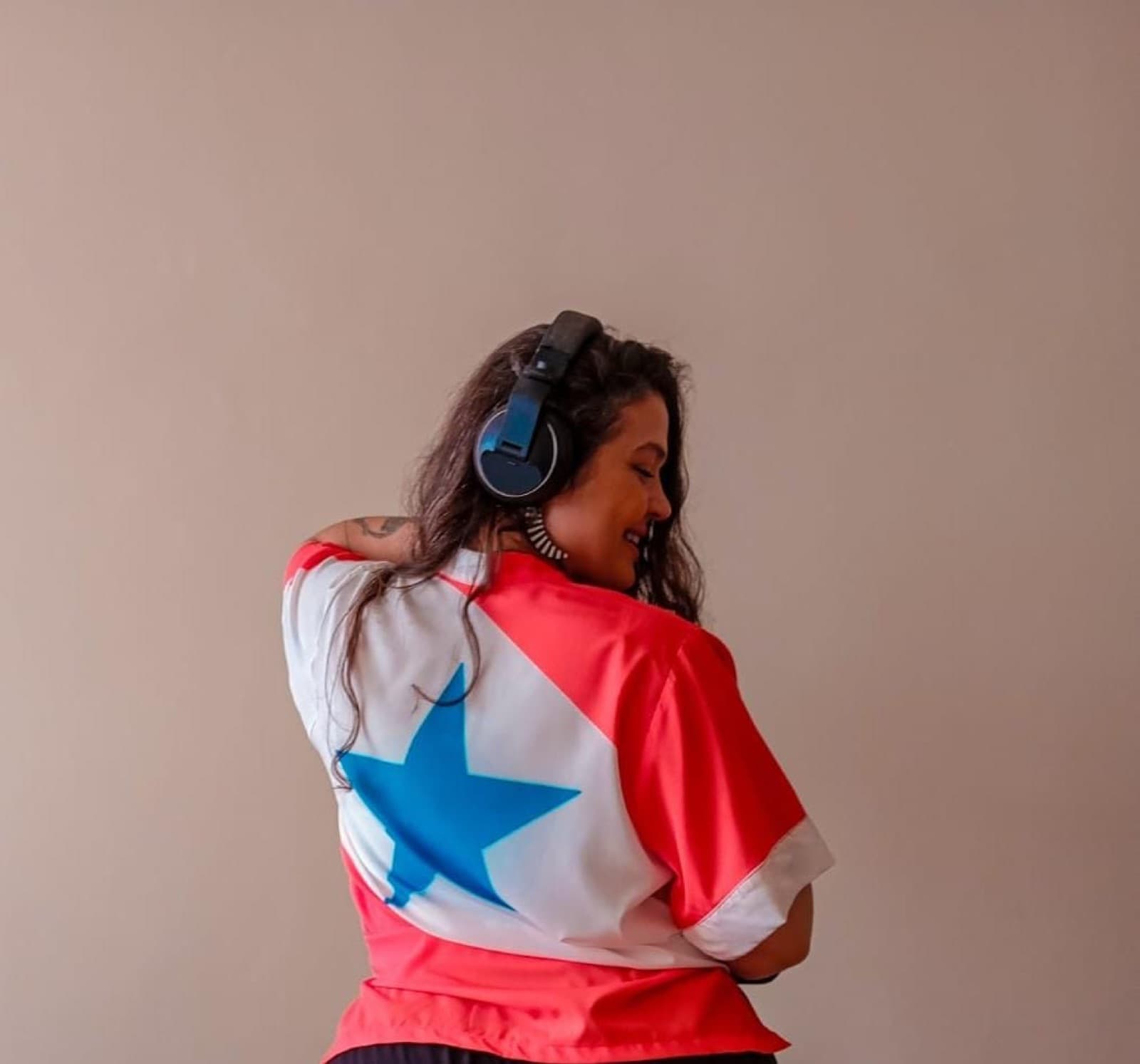 Tha Redig de costas com fones e camiseta de estrela