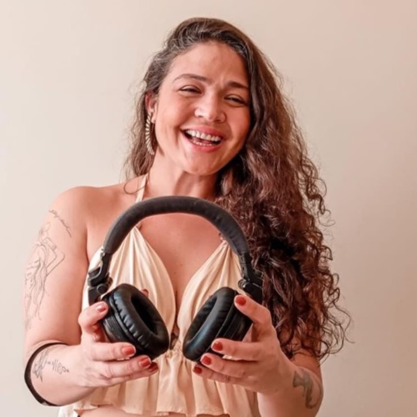 Tha Redig sorrindo segurando fones de ouvido